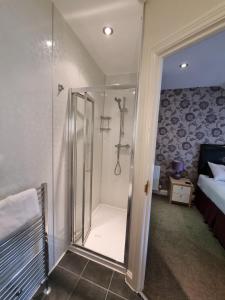 uma casa de banho com um chuveiro e uma porta de vidro em The Fawley Guest house em Shanklin