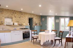 una cucina e una sala da pranzo con tavolo e sedie di Chateau de Flottemanville a Flottemanville