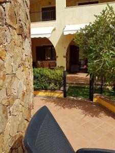 a bench sitting in front of a stone wall at Casa BiBa in Villasimius