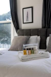 a plastic container on a bed with a towel at The Finsbury Guesthouse in London
