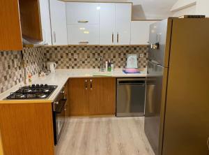 a kitchen with a stainless steel refrigerator and wooden cabinets at BURSA TELEFERIK 4 1 DUPLEX apartment in Yıldırım