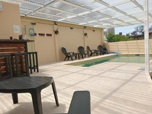 a patio with chairs and a swimming pool at DUPLEX AL SUR in Villa Gesell