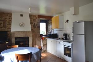a kitchen with a table and a refrigerator at Gite Gloria in Lannion