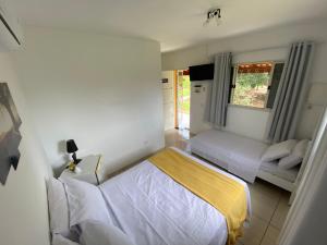 a bedroom with two beds and a window at Família Busca-pé in São Pedro