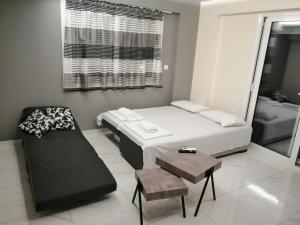 a small room with a bed and a chair at Premium apartman Family in Paralia Katerinis