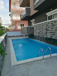 a swimming pool in front of a building at Premium apartman Family in Paralia Katerinis