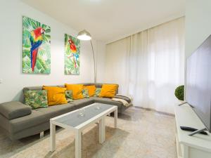 ein Wohnzimmer mit einem Sofa und einem TV in der Unterkunft Surf Brothers in Vecindario