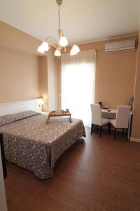 1 dormitorio con 1 cama, mesa y sillas en B&B Hortis Tropea, en Tropea