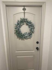 a door with a wreath on it at Utah Valley Retreat - Luxurious Self check-in Apt, UVU BYU, EV Charge in Orem