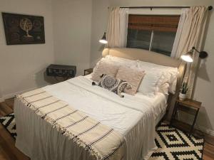 1 dormitorio con 1 cama grande con sábanas y almohadas blancas en Utah Valley Retreat - Luxurious Self check-in Apt, UVU BYU, EV Charge, en Orem