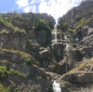 a waterfall on the side of a rocky mountain at Utah Valley Retreat - Luxurious Self check-in Apt, UVU BYU, EV Charge in Orem