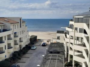 a view of the beach from between two buildings at Résidence Château Leenhardt - Appartement T2 Face à la Mer in Le Grau-du-Roi