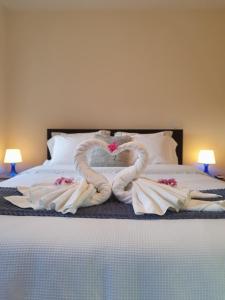 Dos cisnes hechos de toallas en una cama en Casa da Fichua, en Sistelo