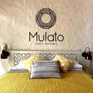 a bedroom with a bed with a muda sign on the wall at Hotel Mulato in El Colegio