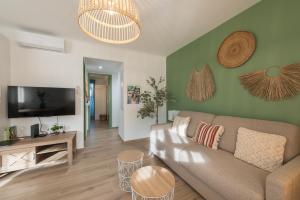 a living room with a couch and a flat screen tv at Le Med - Apartment T2 Confort - Proche plage - Clim - Parking privé in La Ciotat