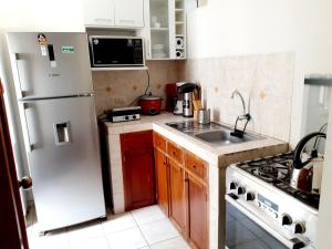 a kitchen with a white refrigerator and a sink at Hermoso Apartamento en el Centro de Trujillo in Trujillo