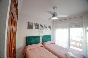 1 dormitorio con cama con sábanas rosas y ventana en "El Balcón de Huelva" lujo en pleno centro, en Huelva