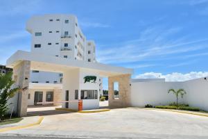 a white building with a parking lot in front of it at Apartamento en Juan Dolio Tepuy 501 B in Juan Pedro