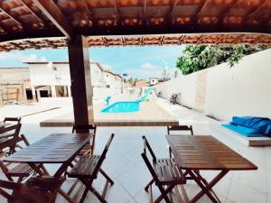 a patio with tables and chairs and a swimming pool at Pousada Brilho dos Lençóis in Barreirinhas