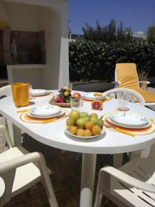 Casa Oliveirinha - Sagres في ساغريس: طاولة بيضاء عليها صحون فاكهة