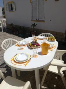 a white table with plates of food on it at Casa Oliveirinha - Sagres in Sagres
