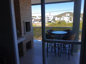 a view of a balcony with a table and stools at DEUS é bom o tempo todo in Governador Celso Ramos