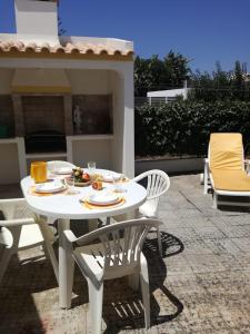 Casa Oliveirinha - Sagres في ساغريس: طاولة بيضاء وكراسي على الفناء