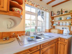 una cocina con fregadero y ventana en Orchard Cottage, en Ashendon 12 fotos más