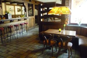 a bar with a wooden table and bar stools at Gasthof Zwilling in Schmallenberg