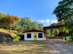 a smallshed with a yellow door next to a road at Hakuna Matata Guest House in Monteverde Costa Rica