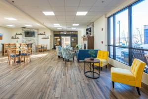 a waiting room with chairs and tables and windows at River Bend Inn - Pigeon Forge in Pigeon Forge