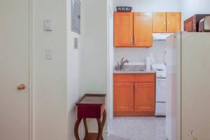 a kitchen with orange cabinets and a white refrigerator at Downtown Studio Apt, Near Grocery And Hospitals in Boston