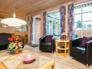 salon z krzesłami i stołem w obiekcie 10 person holiday home in Oksb l w mieście Øster Vrøgum