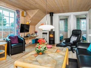 salon z kanapą, krzesłami i kominkiem w obiekcie 10 person holiday home in Oksb l w mieście Øster Vrøgum