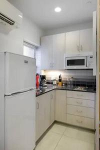 a kitchen with white cabinets and a white refrigerator at Small Fully Equipped Contemporary Studio Near MGH in Boston