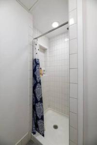 a bathroom with a shower with a blue shower curtain at Small Fully Equipped Contemporary Studio Near MGH in Boston