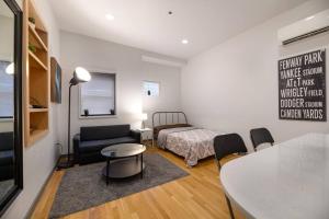 ein Wohnzimmer mit einem Sofa, einem Tisch und einem Bett in der Unterkunft Modern Studio In City Center, Near Boston Common in Boston