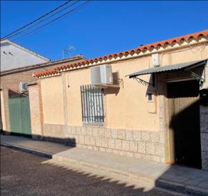 un bâtiment en briques avec une porte et un portail dans l'établissement Casa Alberche a 9Km Talavera, à Alberche del Caudillo