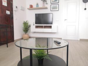 ein Wohnzimmer mit einem Glastisch und einem TV in der Unterkunft Lovely Modern Flat Valencia center in Valencia