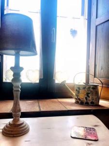 a lamp sitting on a table next to a window at Casale delle Rondini in Tolentino