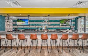 a bar in a restaurant with orange stools at Oceanfront Suite Grande Cayman 124 in Myrtle Beach