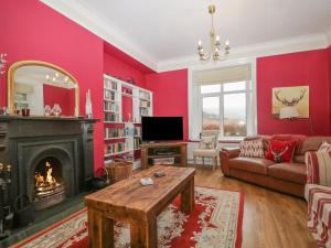 a living room with red walls and a fireplace at The Old Vicarage in Thirlmere