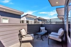 a patio with two chairs and a table on a balcony at Private Rooftop Patio + 4 Story Home in Downtown FW in Fort Worth