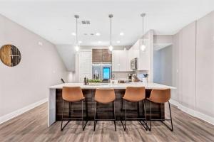 a kitchen with a large island with chairs at Private Rooftop Patio + 4 Story Home in Downtown FW in Fort Worth