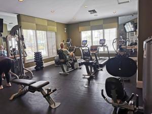 a gym with people exercising on machines in it at GreenLinks Luxury Villa at Lely Resort Golf - 3 Bedrooms in Naples