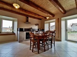 una cucina con tavolo e sedie in legno di Gîte rénové au cœur de l'Auvergne - FR-1-582-336 ad Arlempdes Altre 14 foto