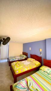 3 posti letto in una camera con pareti blu di Hotel Turista Real a Bucaramanga