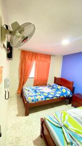 una camera da letto con un letto e un ventilatore a soffitto di Hotel Turista Real a Bucaramanga