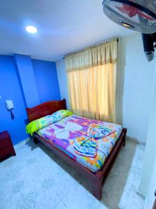 una camera da letto con un letto e una finestra di Hotel Turista Real a Bucaramanga