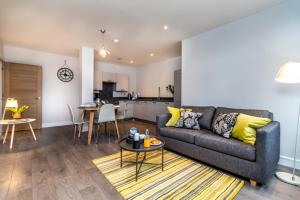 a living room with a couch and a table at Geneva House Apartments by Elegance Living in Peterborough